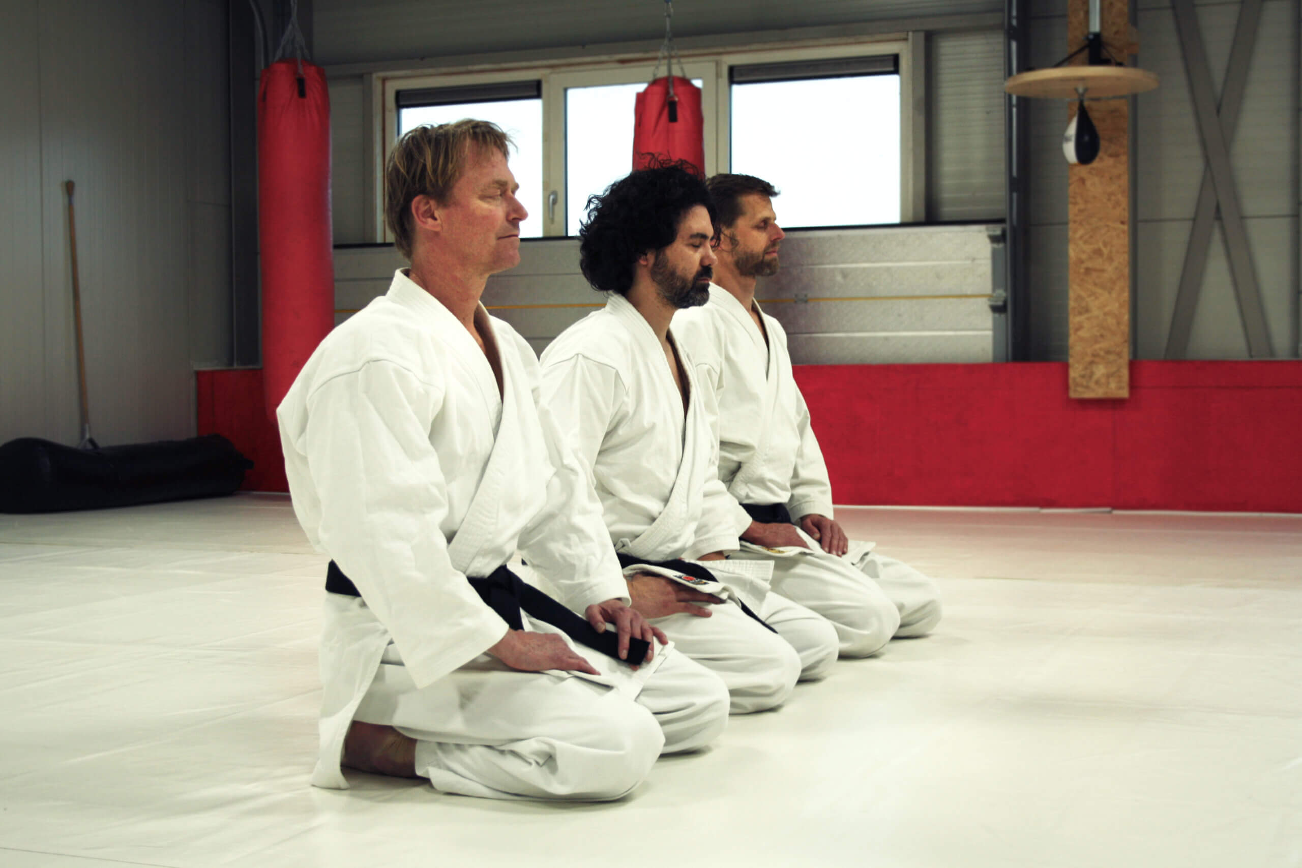 Drie eigenaars van Dojo Shiro in Ooij doen ademhalingsoefening in hun dojo